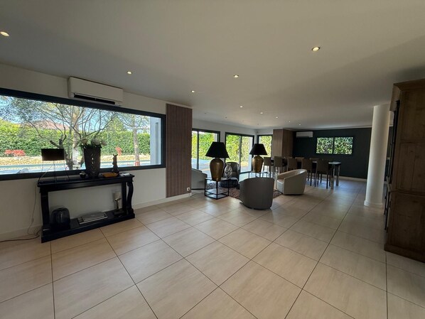 A spacious living room with a large window, a fireplace, and a dining area.