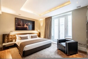 Ein modernes Hotelzimmer mit einem großen Bett, einer Sitzecke und einem großen Fenster.