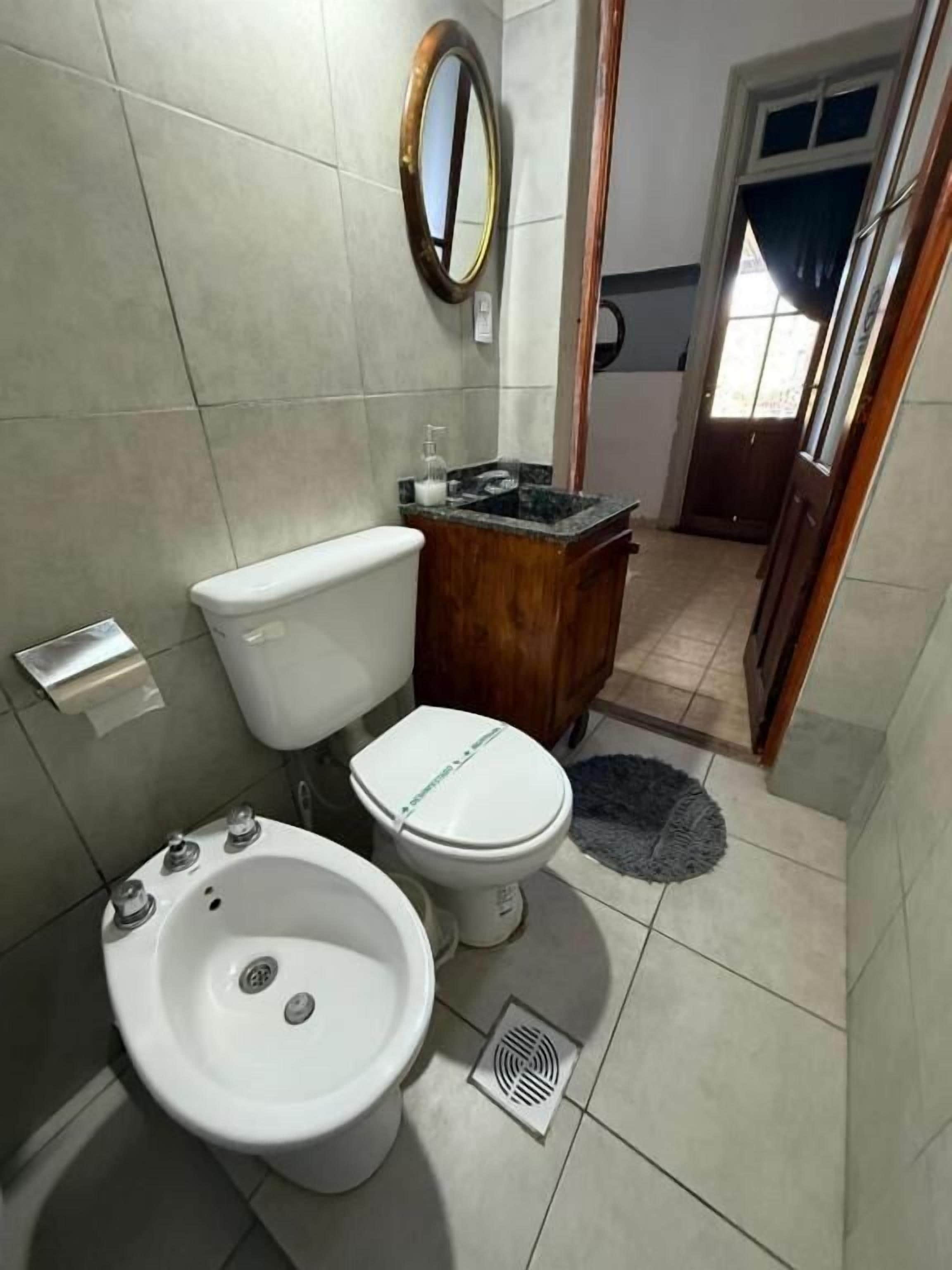 A bathroom with a toilet, bidet, and sink.