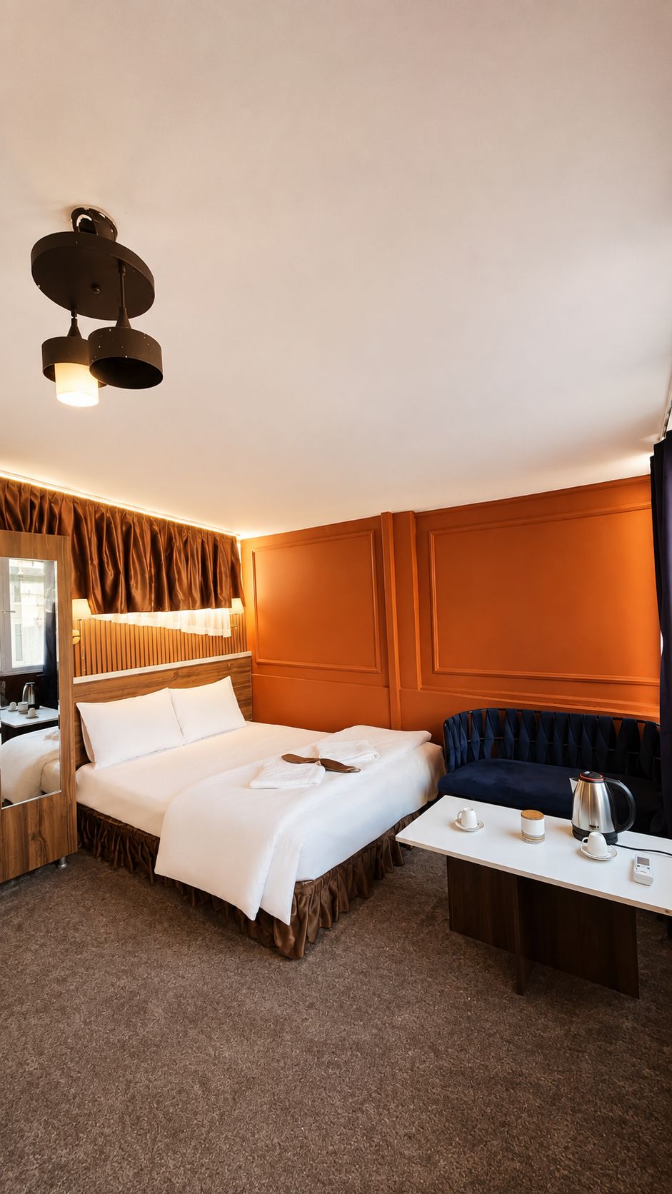 Ein Hotelzimmer mit Bett, Nachttisch und einer Sitzecke mit Tisch und Stühlen.
