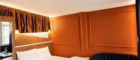 A hotel room with a bed, bedside table, and a seating area with a table and chairs.
