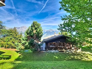 Eine Bergingerhütte mit einer Holzdiele und Blick auf die Berge.