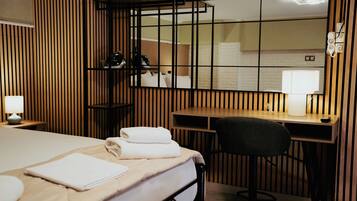 A hotel room with a bed, a desk, and a chair.