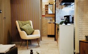 A modern kitchen with a built-in stove, a wooden cabinet, and a white countertop. - Koukaki Premium Lofts (Athina)