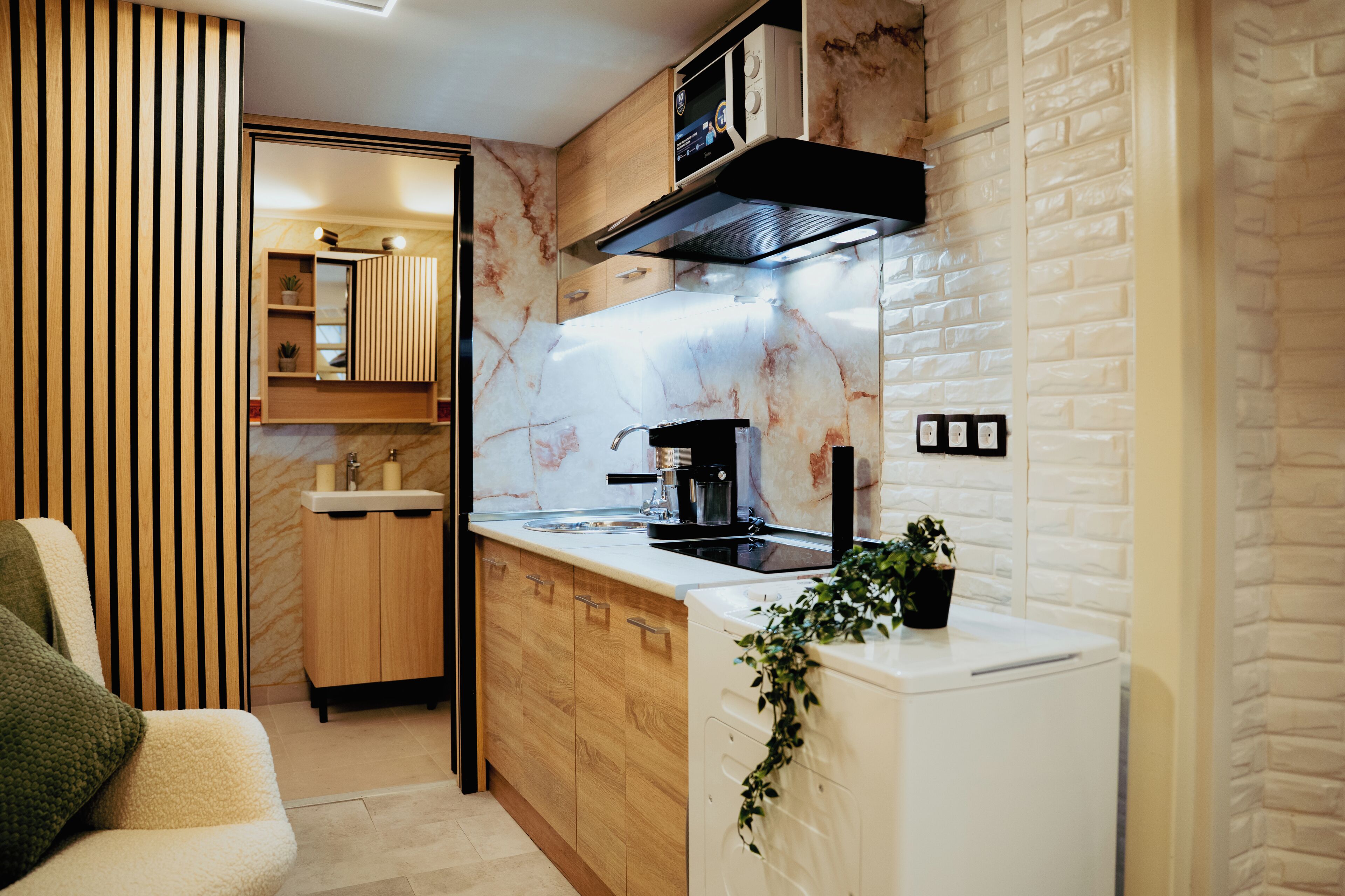 A compact kitchen with a built-in stove, a coffee machine, and a microwave.