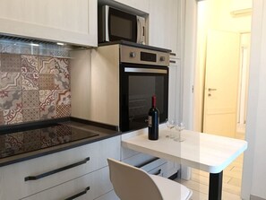 Eine moderne Küche mit Einbauofen, Mikrowelle und einem gemusterten Rückwand.