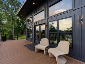 Ein modernes Äußeres mit großen Fenstern und einer Holzterrasse.