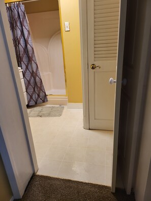 A bathroom with a shower, a toilet, and a bathtub.