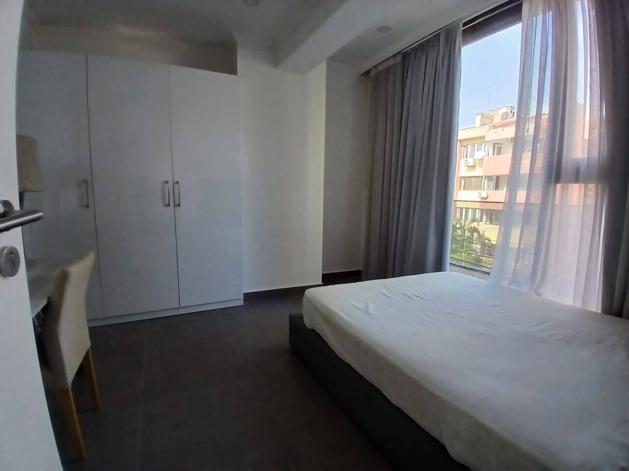 Een hotelkamer met een bed, een bureau en een kledingkast.