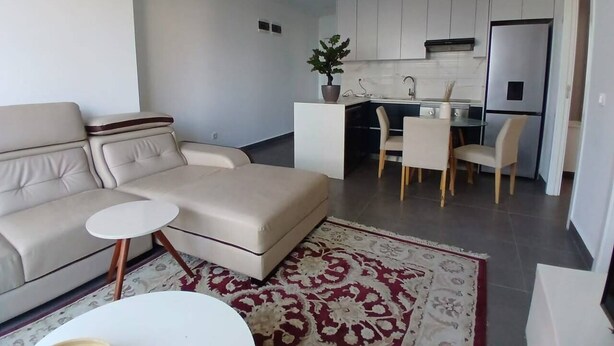 Un salon moderne avec un canapé, une petite table ronde et un tapis à motifs.