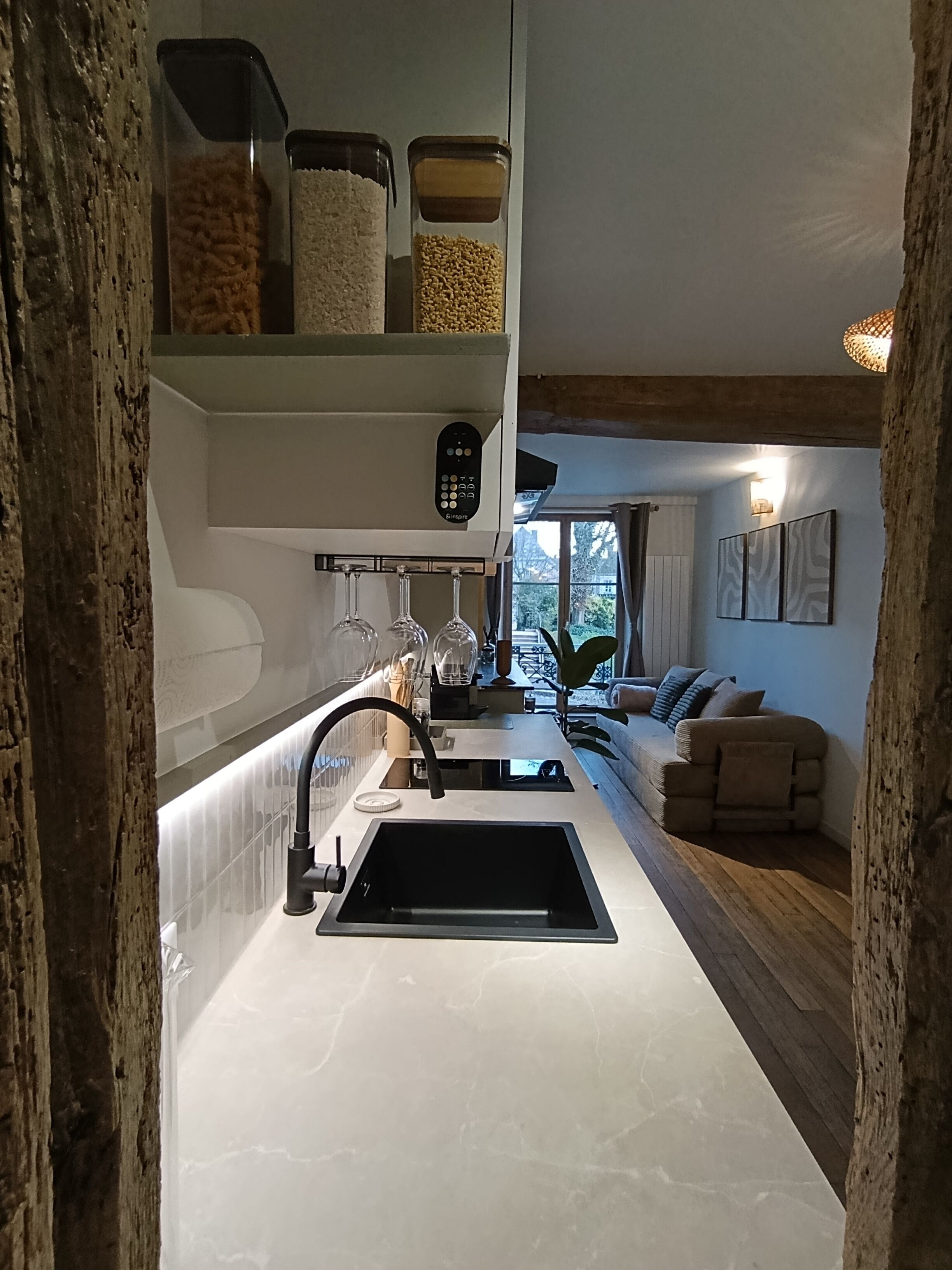 Une cuisine au design moderne, dotée d’un évier encastré, d’un panneau de commande et d’un plan de travail muni de boîtes de rangement.