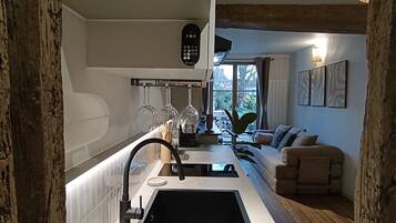 Une cuisine au design moderne, dotée d’un évier encastré, d’un panneau de commande et d’un plan de travail muni de boîtes de rangement.
