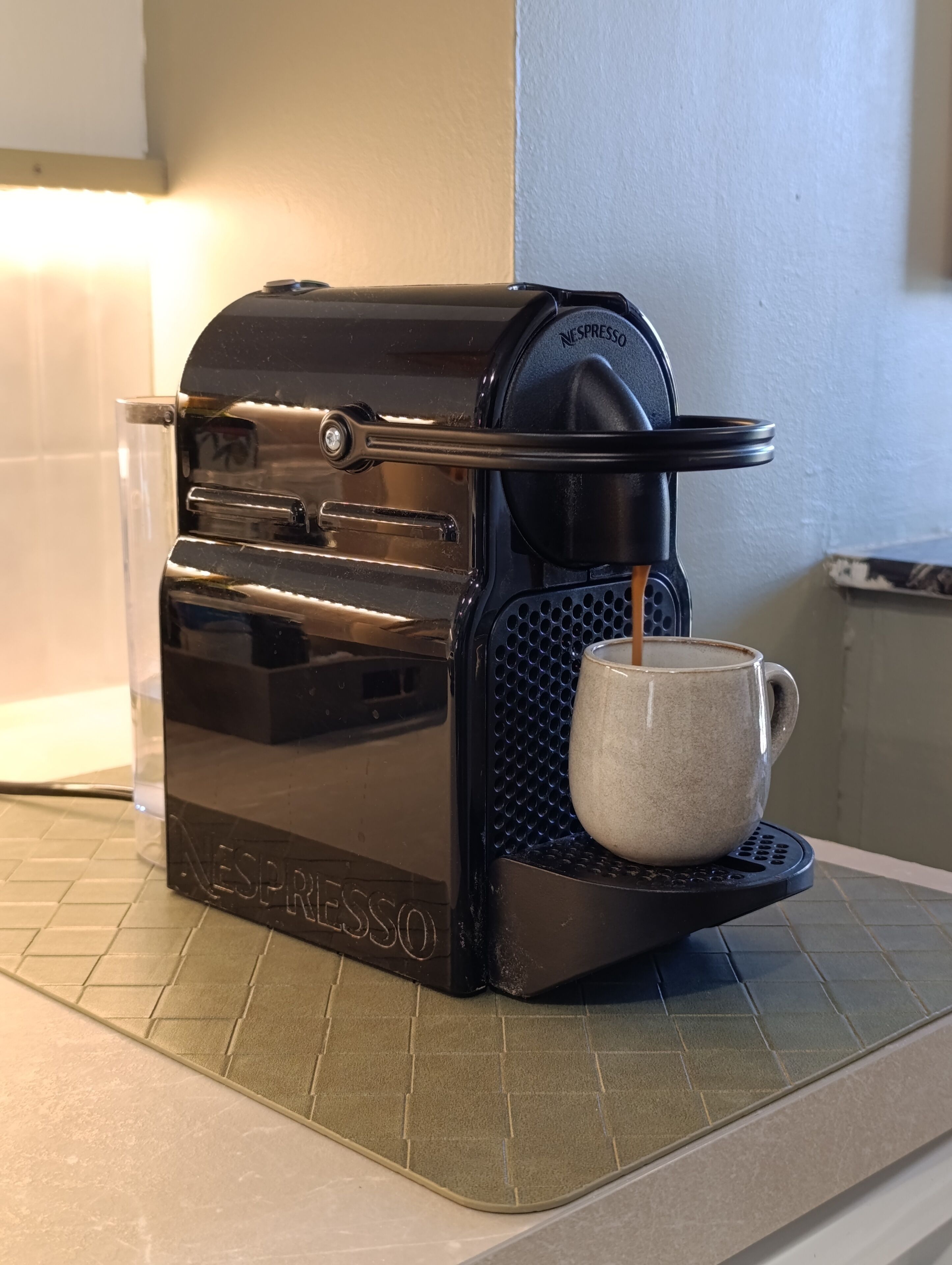 Eine Nespresso-Kaffeemaschine mit einer Kaffeetasse auf dem Tropfbecken.