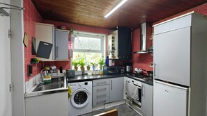 A compact kitchen with a washing machine, a microwave, and a stove. - Single room In Manchester's famous curry mile (Manchester)
