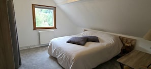 A bedroom with a bed, a window, and a radiator. - Domaine du Rouhu (Fouchy)