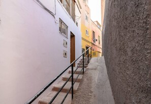 Um beco estreito com uma escadaria que leva a um edifício com uma porta.