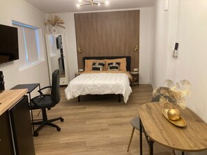 Ein modernes Schlafzimmer mit einem Bett, Nachttischen, einem Schreibtisch und einem Stuhl.
