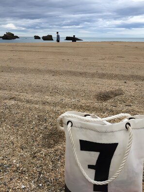 A beach with pebbles and a white bag with a number on it. - House 'La Rue, Petite Maison de Pêcheur proche plage' (Cancale)