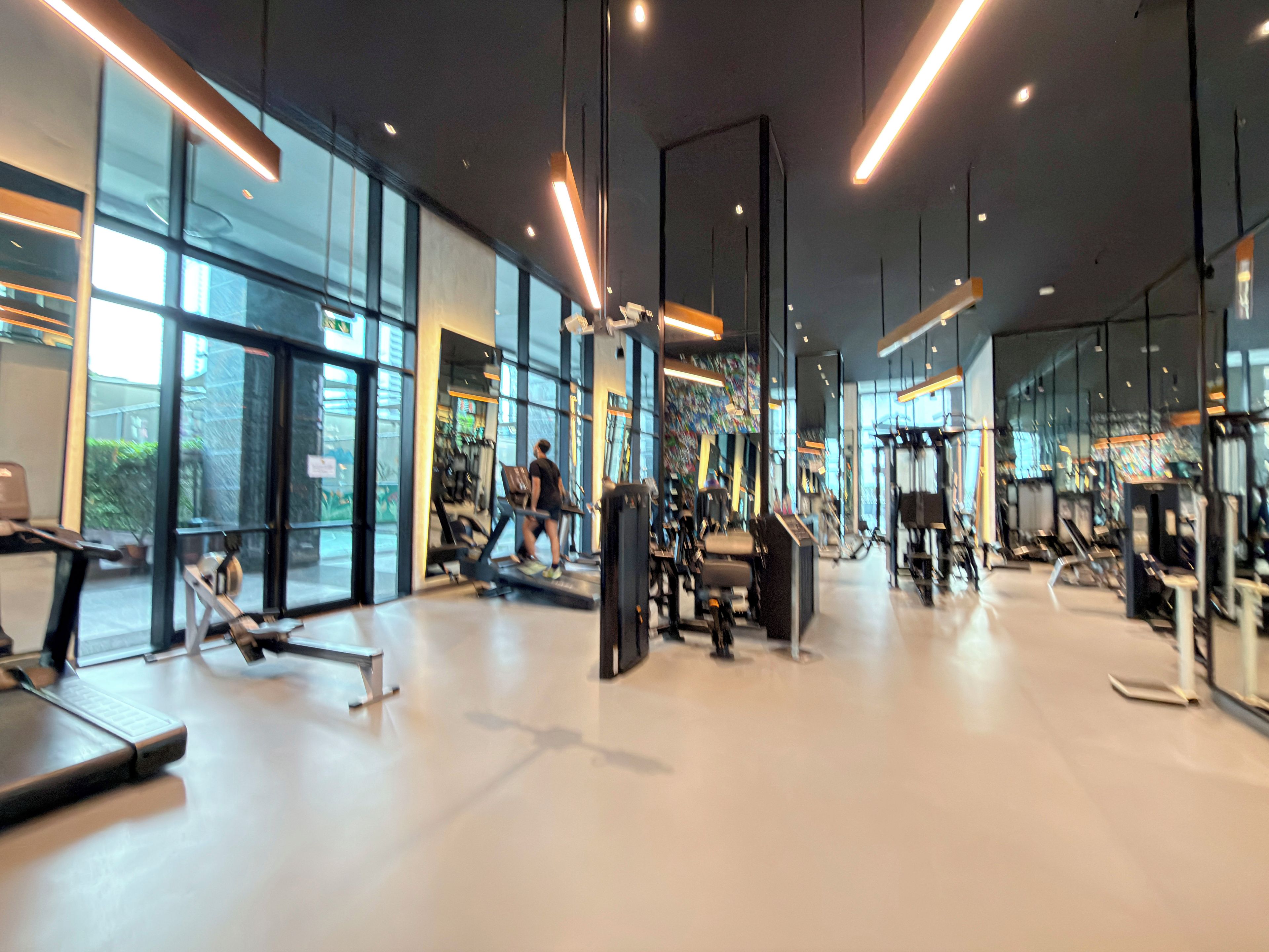Une salle de sport moderne, dotée d’équipements d’exercice, de grandes fenêtres et d’un intérieur propre et spacieux.