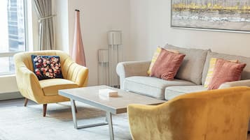 Ein modernes Wohnzimmer mit einem gelben Sessel, einem grauen Sofa und einem Couchtisch.