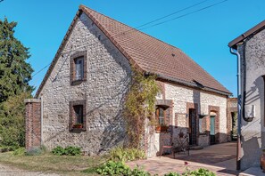 Ein Steinhaus mit geneigtem Dach, einem kleinen Fenster und einer Tür.
