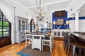 A spacious kitchen with a dining area, wooden flooring, and a chandelier. - Fire Pit, Grill, Smoker | 3 Min to Aquarium, 4 Min to Beach! (Gulfport)