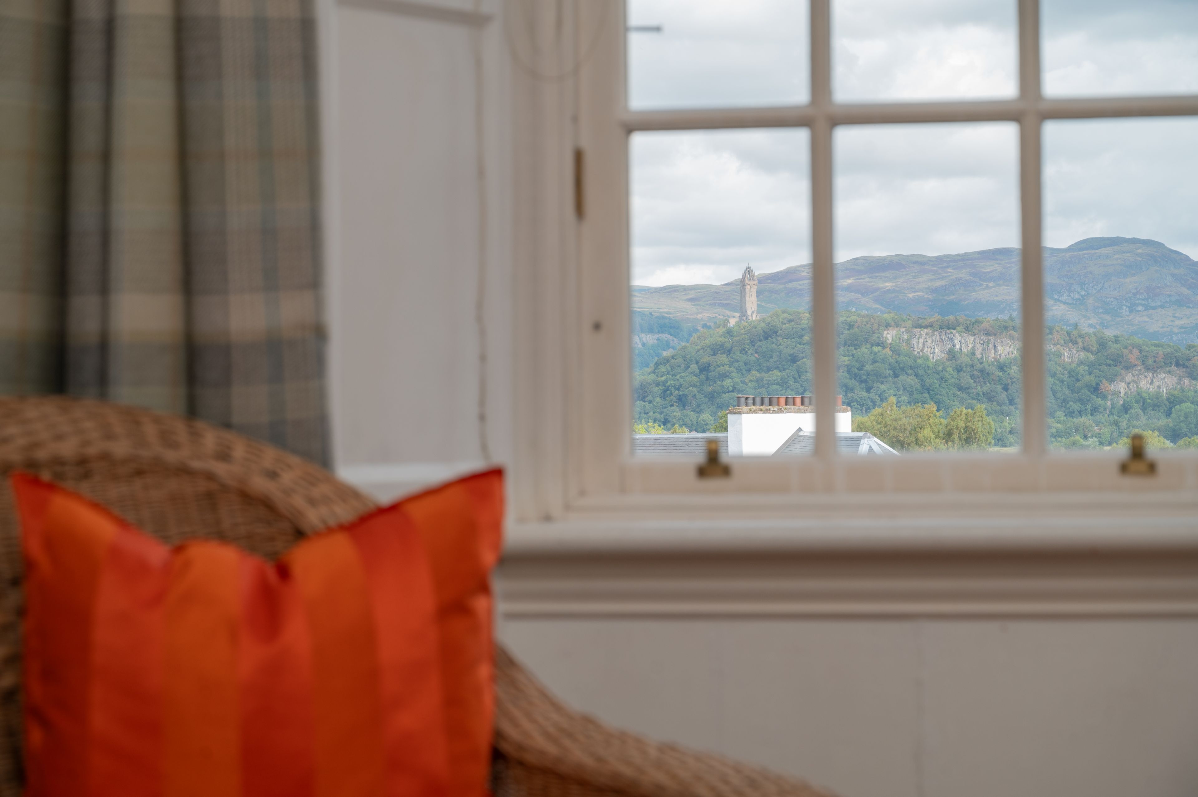 A room with a window overlooking a mountainous landscape.