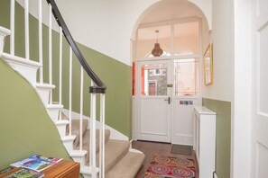 A staircase with white balusters, a green wall, and a carpeted landing area. - Banrigh House - a terrace that sleeps 6 guests in 3 bedrooms (Stirling)