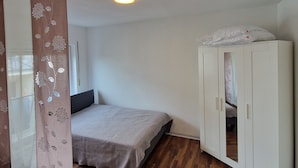 A bedroom with a bed, a wardrobe, and a ceiling light. - Apartment "Sala Uno" with Wi-Fi (Coswig)