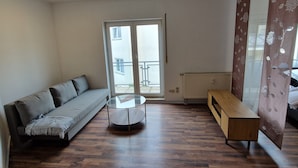 A modern living room with a sofa, a glass coffee table, and a wooden cabinet. - Apartment "Sala Uno" with Wi-Fi (Coswig)