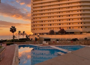 A hotel with a pool area and a view of the ocean at sunset. - Apolo Mediterranean Living (Marbella)