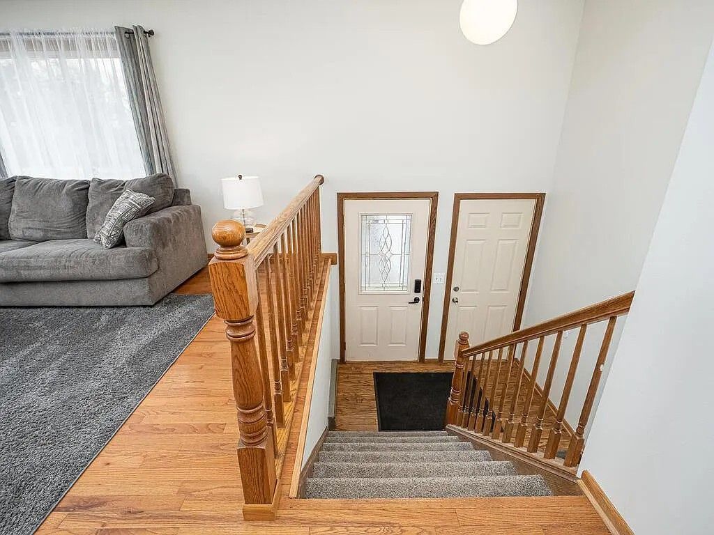 Un escalier avec des rampes en bois menant à un palier doté de deux portes.