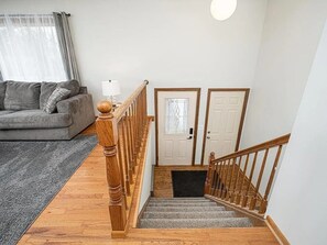 Una escalera con barandas de madera que lleva a un rellano con dos puertas.