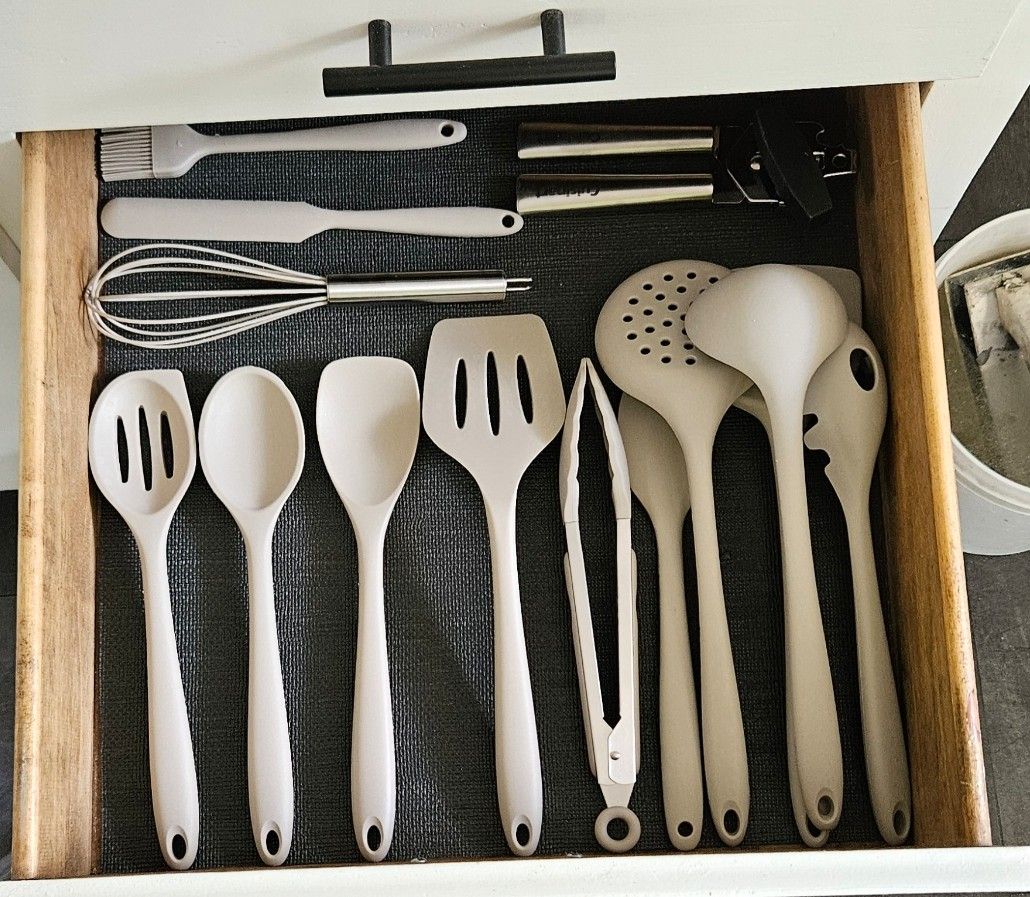 Een lade gevuld met verschillende keukengereedschappen, zoals spatels, lepels en mixers.