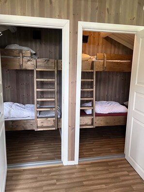 A room with two bunk beds, each with a ladder, wooden walls, and a wooden floor. - Cosy Camping Cabin no. 12 in Øyer (Øyer)