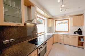 A modern kitchen with granite countertops, stainless steel appliances, and wooden cabinets. - Rauris House, Hohe Tauern National Park (Rauris)