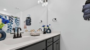 Casa de banho moderna com um espelho grande, duas pias e uma toucador com armários.