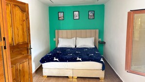 Ein Schlafzimmer mit einem Bett, einem Holzschrank und einem Fenster.