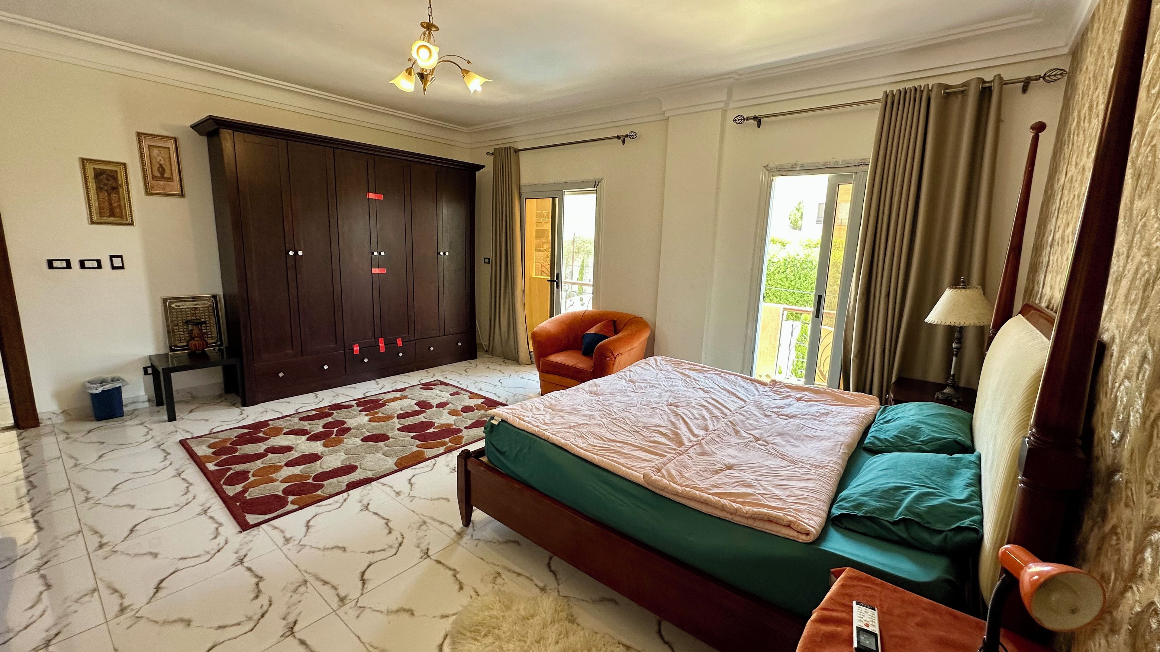 Ein Schlafzimmer mit Bett, Stuhl, Kleiderschrank und Fenster.