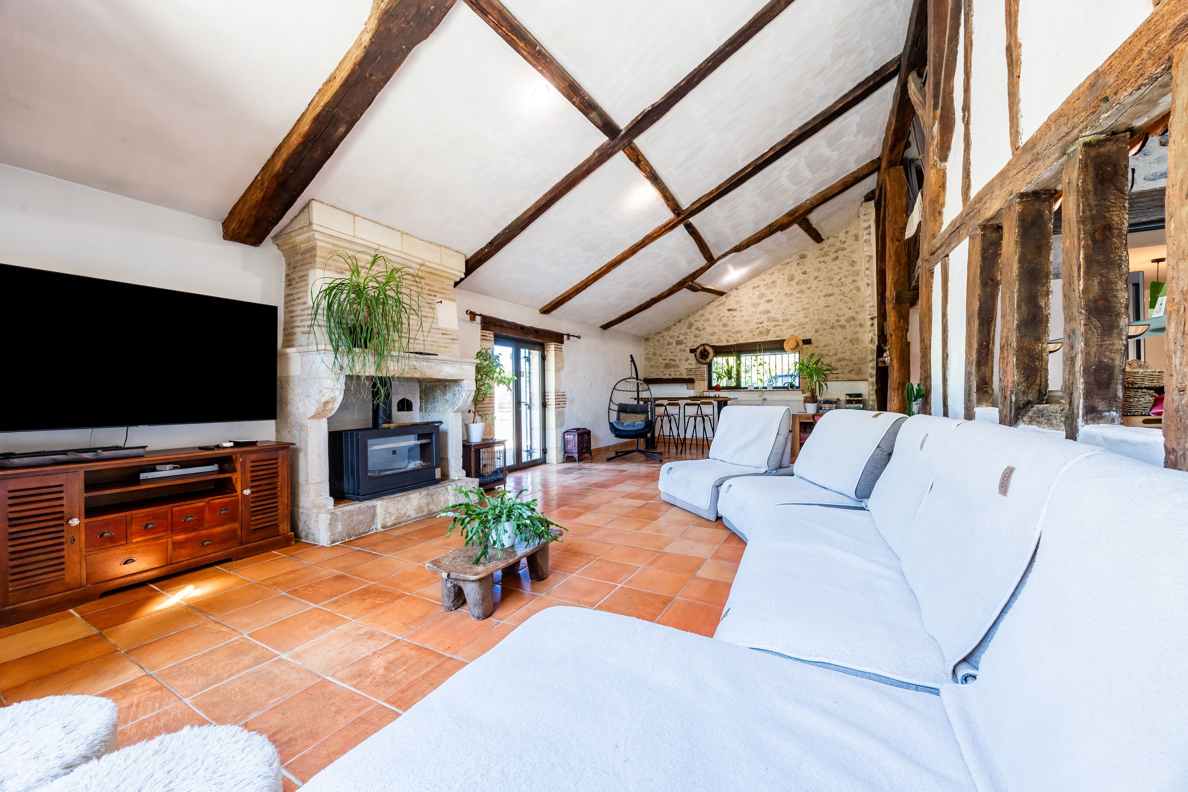 Un amplio salón con un sofá modular grande, una chimenea y un televisor.