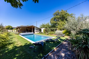 A backyard with a swimming pool, two lounge chairs, and a covered patio area. - Holiday Home 'Domaine Liminalis' with Private Terrace, Garden and Wi-Fi (Saint-Martin-Petit)