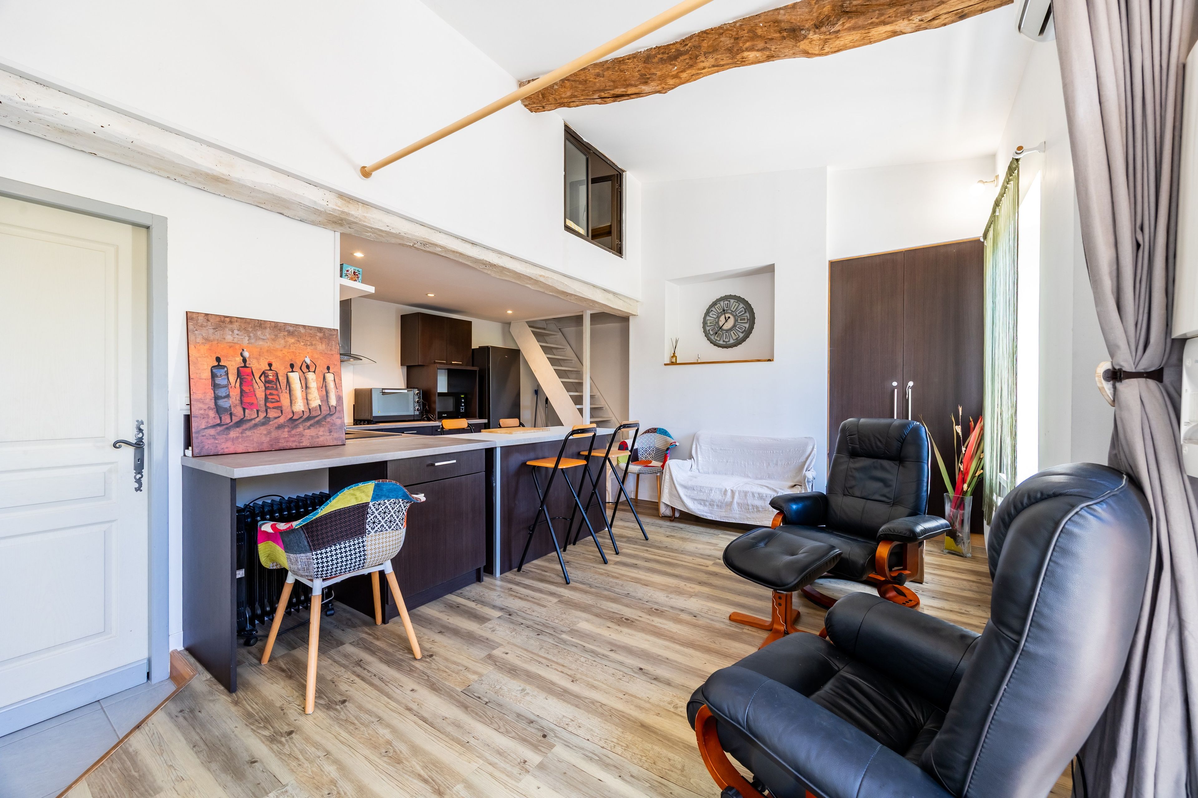 Un espace de vie moderne comprenant une cuisine, un coin repas et un espace détente.