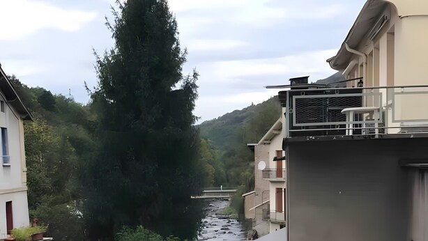 Un canal estrecho entre edificios, con un puente a lo lejos.