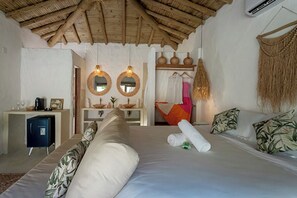 A bedroom with a bed, bedside tables, a wardrobe, a mirror, and a hanging basket. - Vila Bem Te Vi (Porto Seguro)