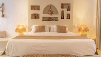 Una habitación de hotel con una cama grande, dos lámparas de noche y un estante en la pared con adornos.