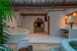 A modern bathroom with a large bathtub, a shower, and a sink area. - Vila Bem Te Vi (Porto Seguro)