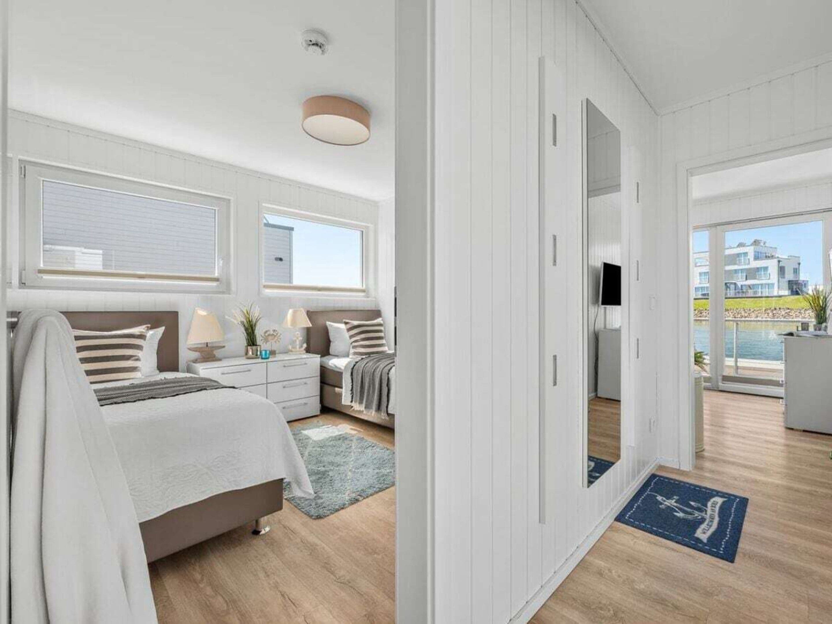 A modern bedroom with a bed, bedside tables, and a view of the outside.