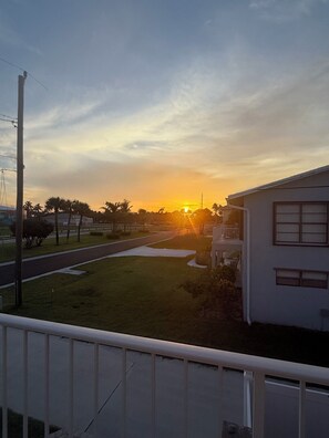 A residential area with a house, a road, and a sunset. - Intercoastal Cove Retreat - Upstairs Island Escape with Water Views (Fort Pierce)