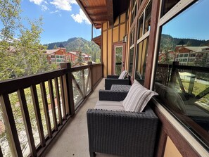 A balcony with wicker furniture and a view of a mountainous area. - Honeycomb Reserve by Cottonwood Lodging (UNDER RENOVATION) (Solitude)