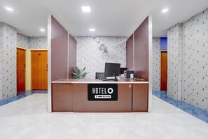 A hotel reception desk with a sign indicating it is serviced by OYO.